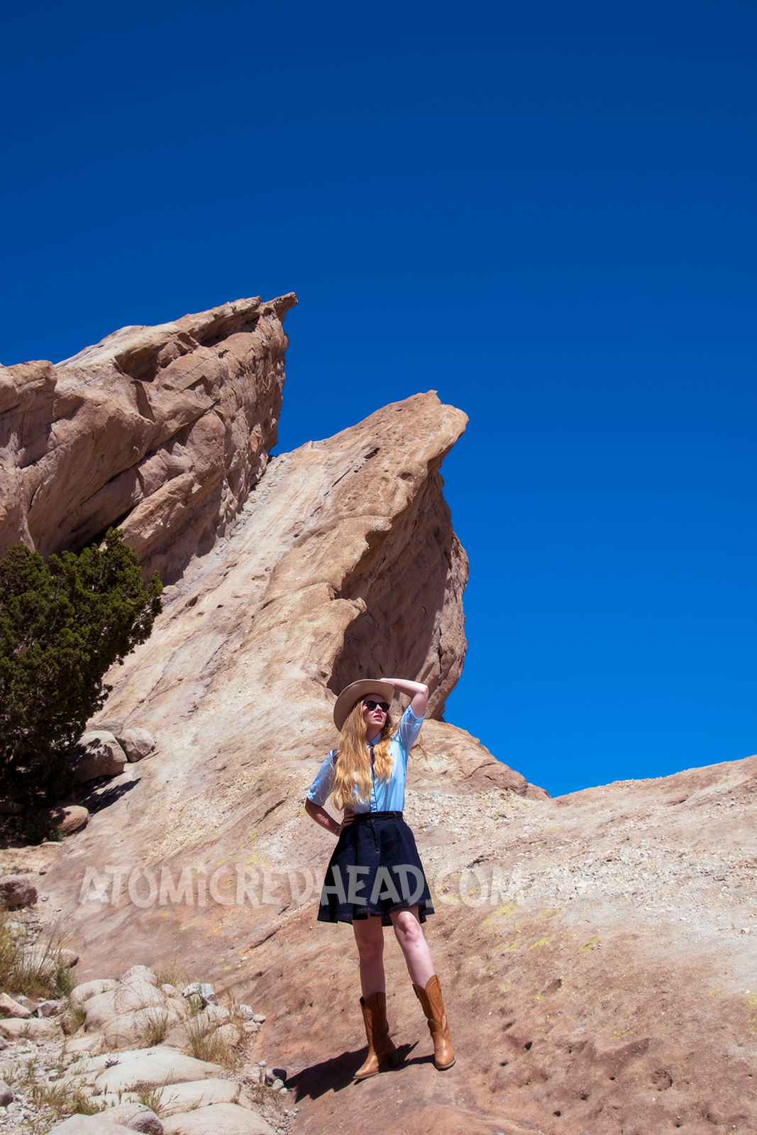 Atop Vasquez Rocks in a denim skirt, two-tone western shirt, UFO bolo tie by Kesha, and a cream western wear hat.