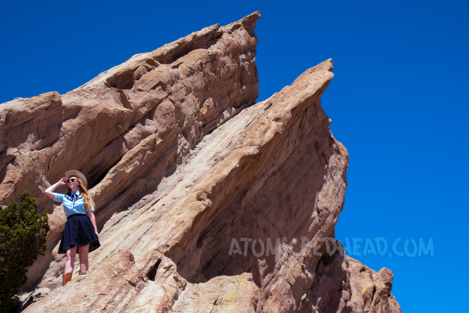 Atop Vasquez Rocks in a denim skirt, two-tone western shirt, UFO bolo tie by Kesha, and a cream western wear hat.