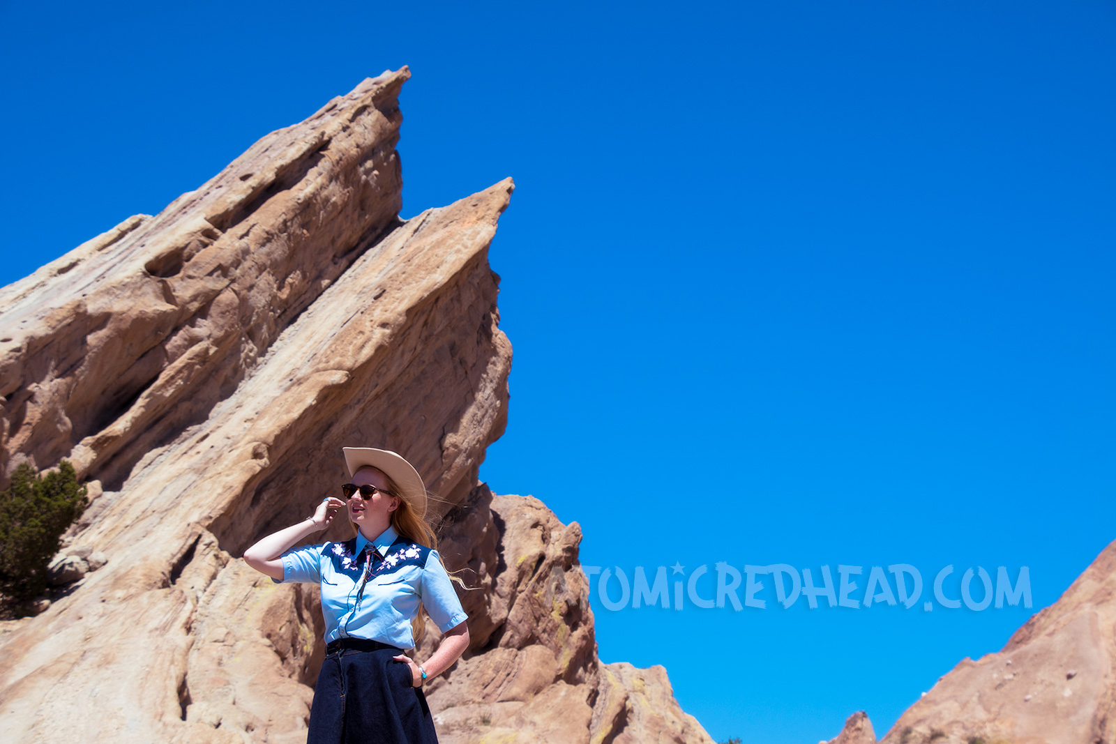 Atop Vasquez Rocks in a denim skirt, two-tone western shirt, UFO bolo tie by Kesha, and a cream western wear hat.