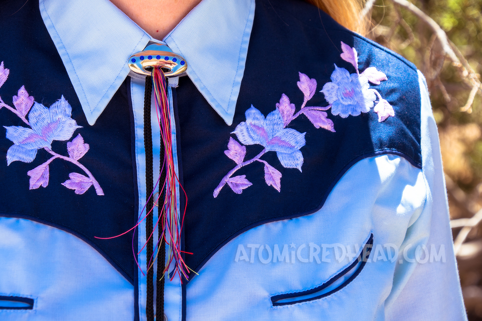 Close-up of the embroidery of my top - pink and white flowers, and a UFO bolo tie.