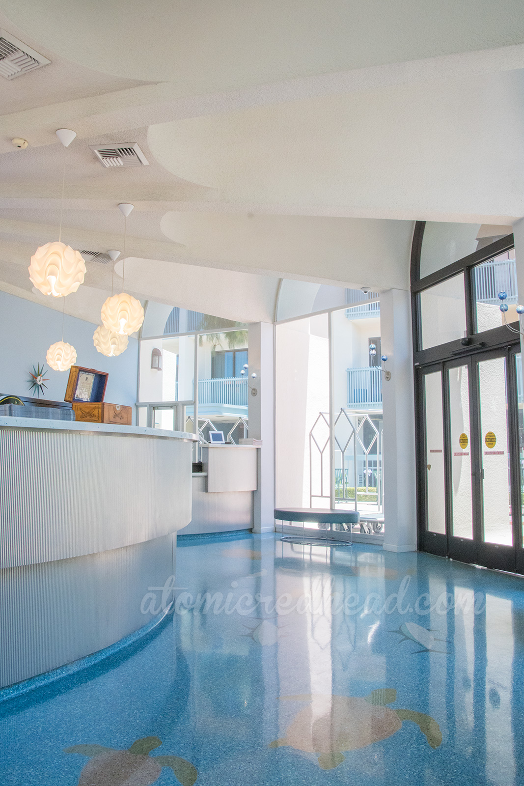 Inside the lobby, with white walls, a graceful wavy check-in counter.