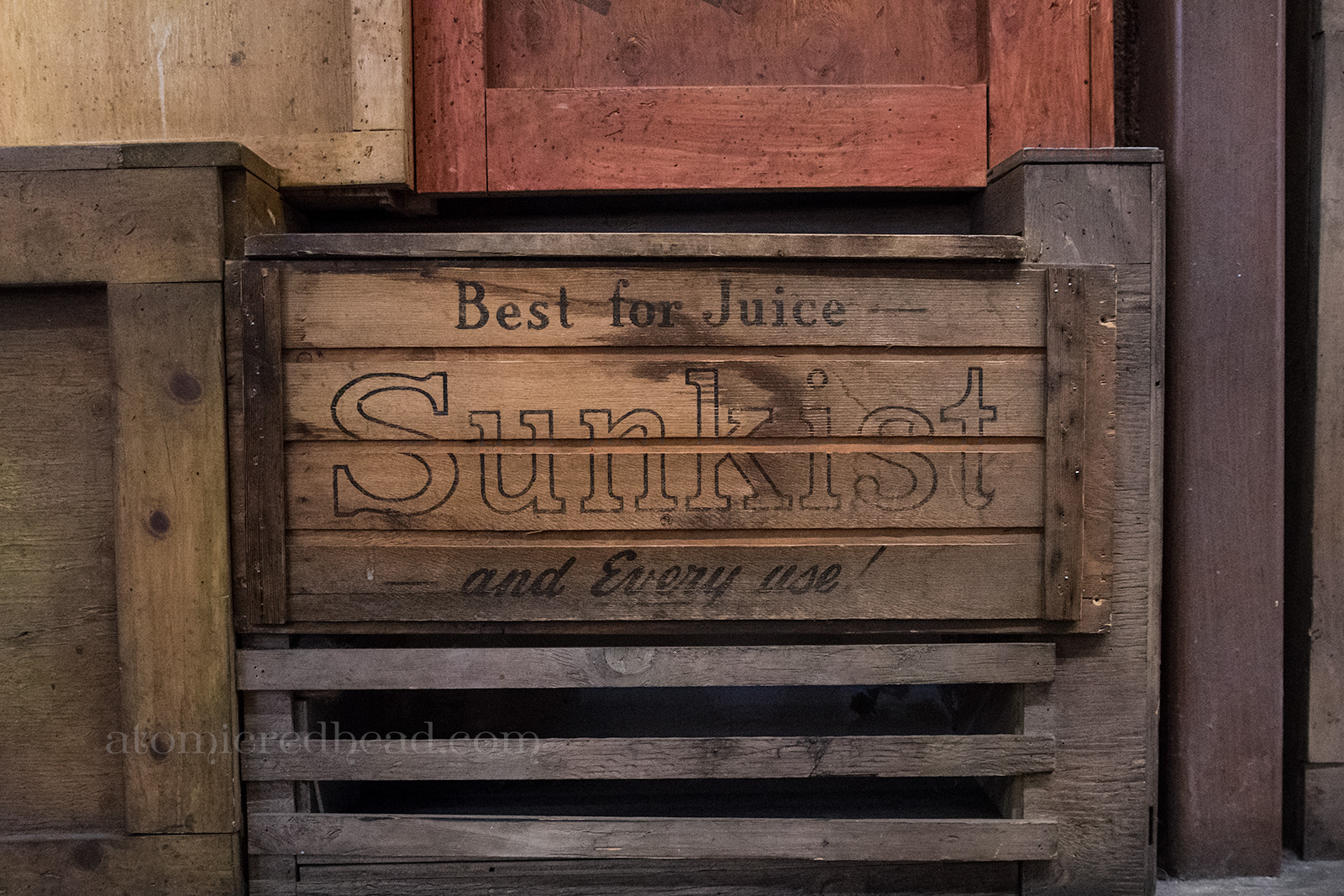 Old crates line a wall, including an old Sunkist crate