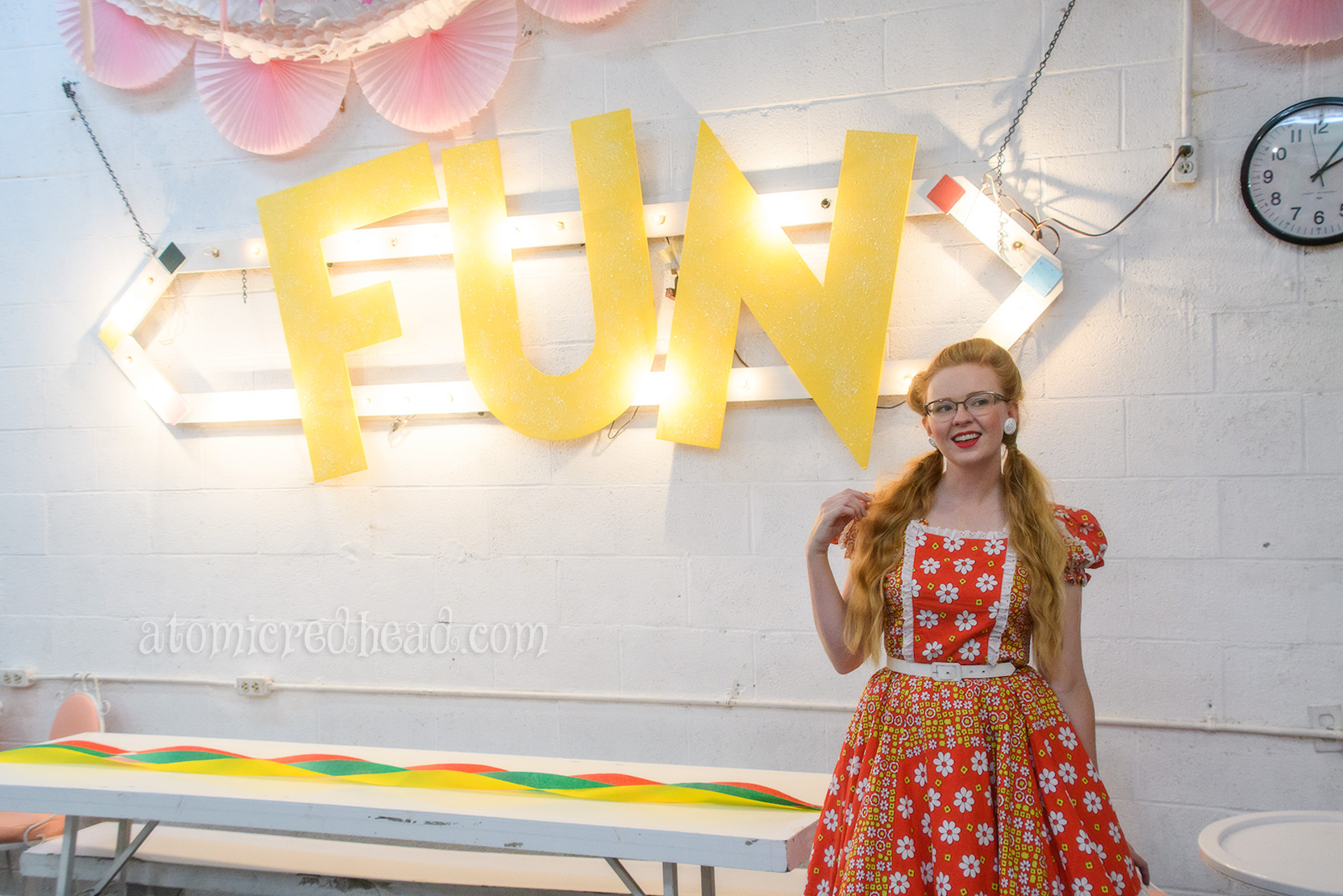 Standing inside the party room where "FUN" is spelled out in large yellow letters.