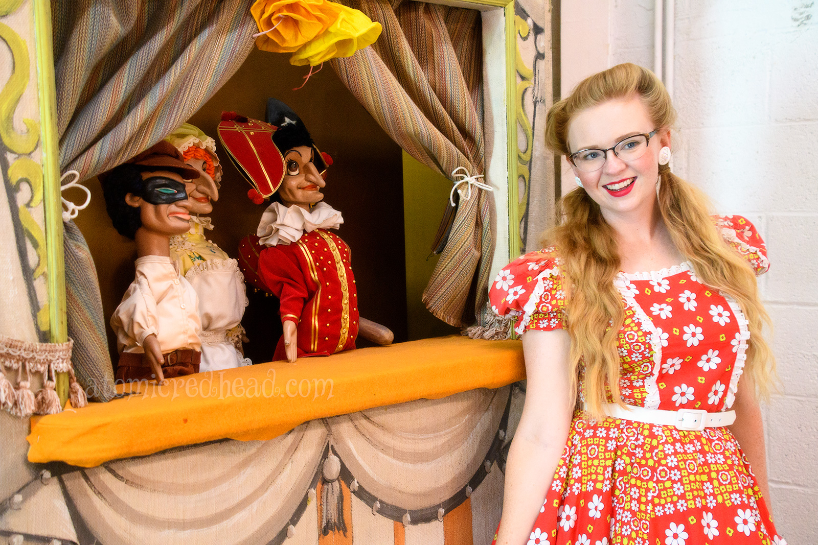 Standing next to one of the traveling theaters, where puppets sit.