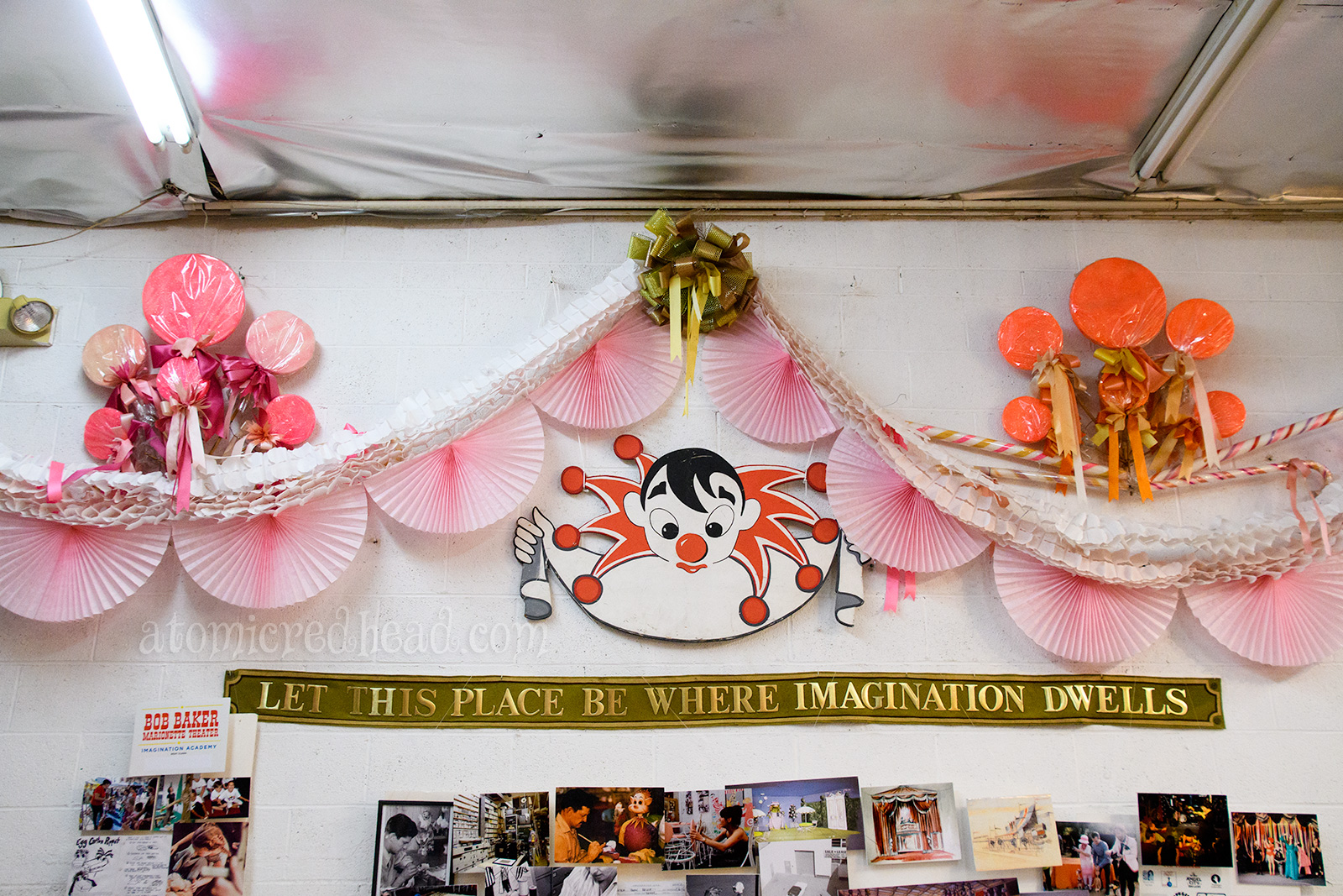 A banner reading "Let this place be where imagination dwells" hangs above photos, a playful hand painted clown looks down.