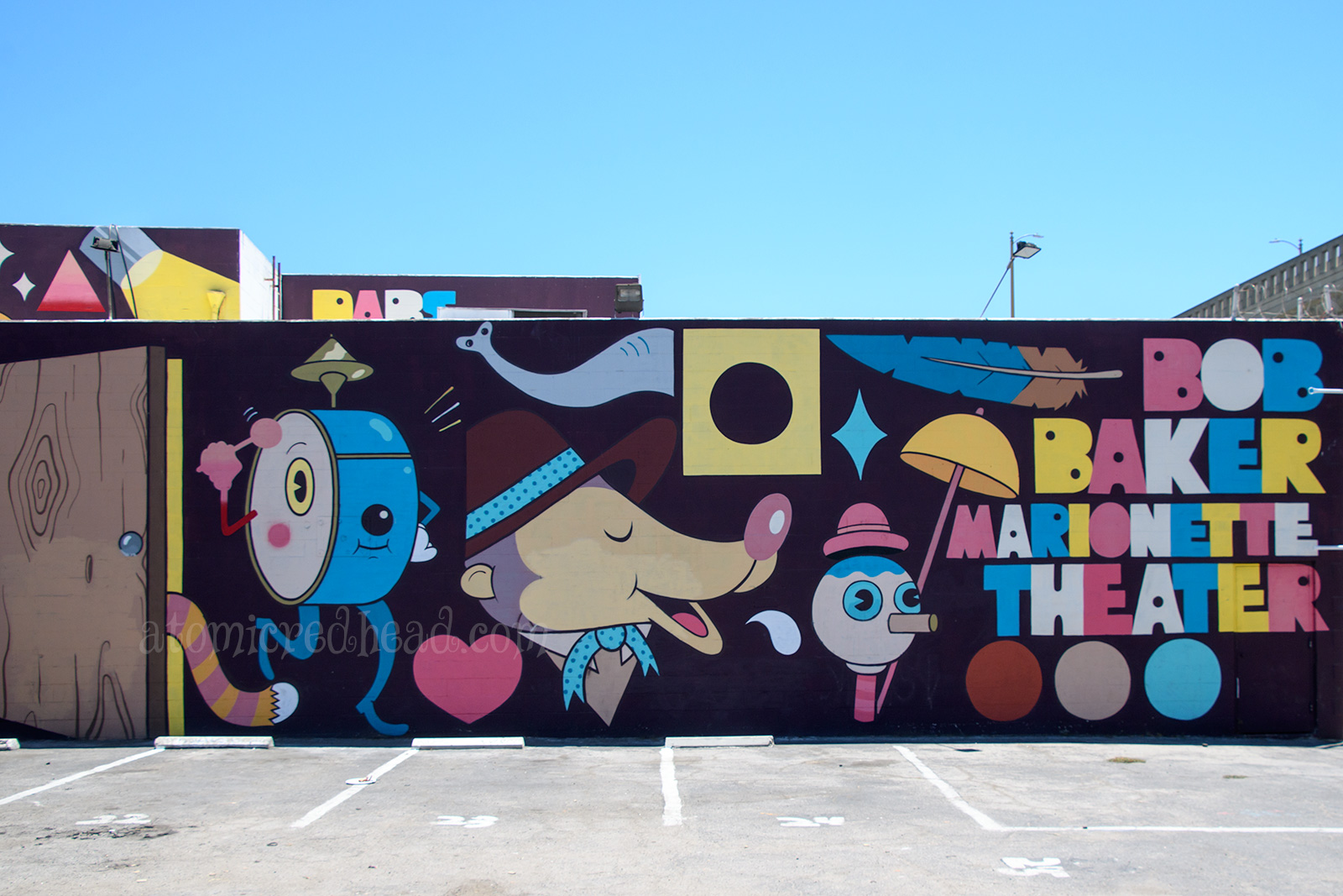 The mural outside of the theater, featuring a large drum that plays itself, a bear, and other quirky shapes.
