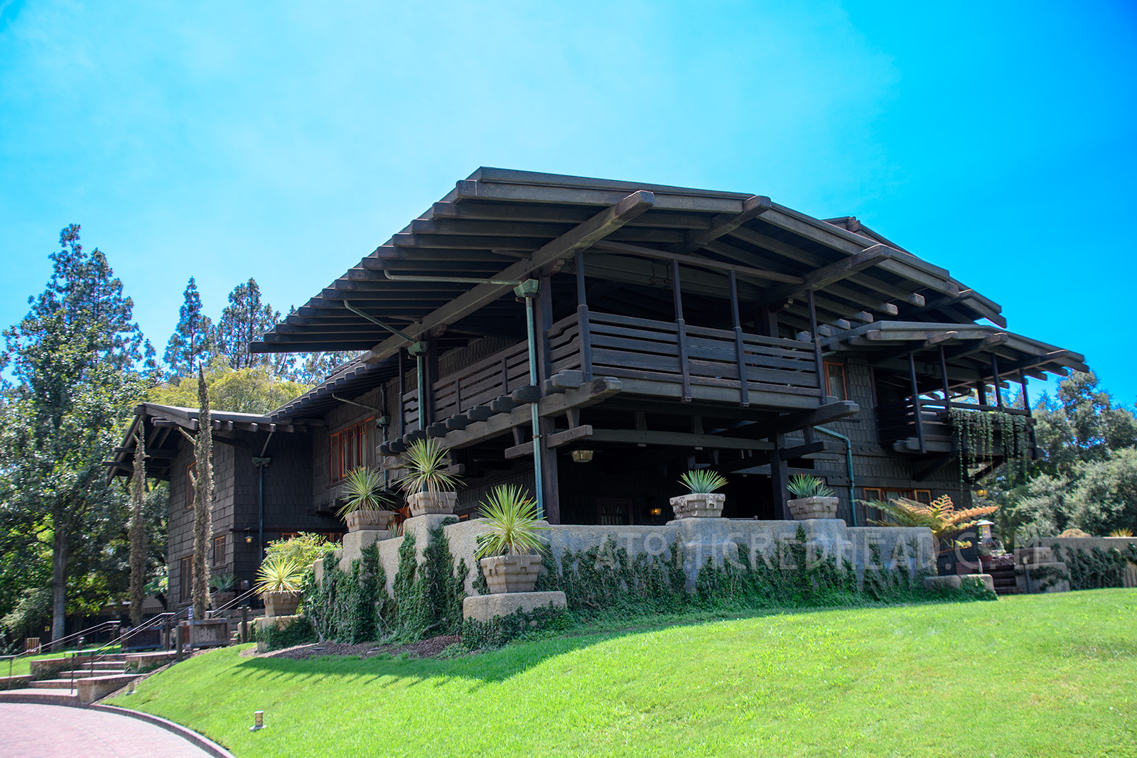 Exterior of the Gamble House, a three story Craftsman style house, with two large sleeping porches, and overhangs.