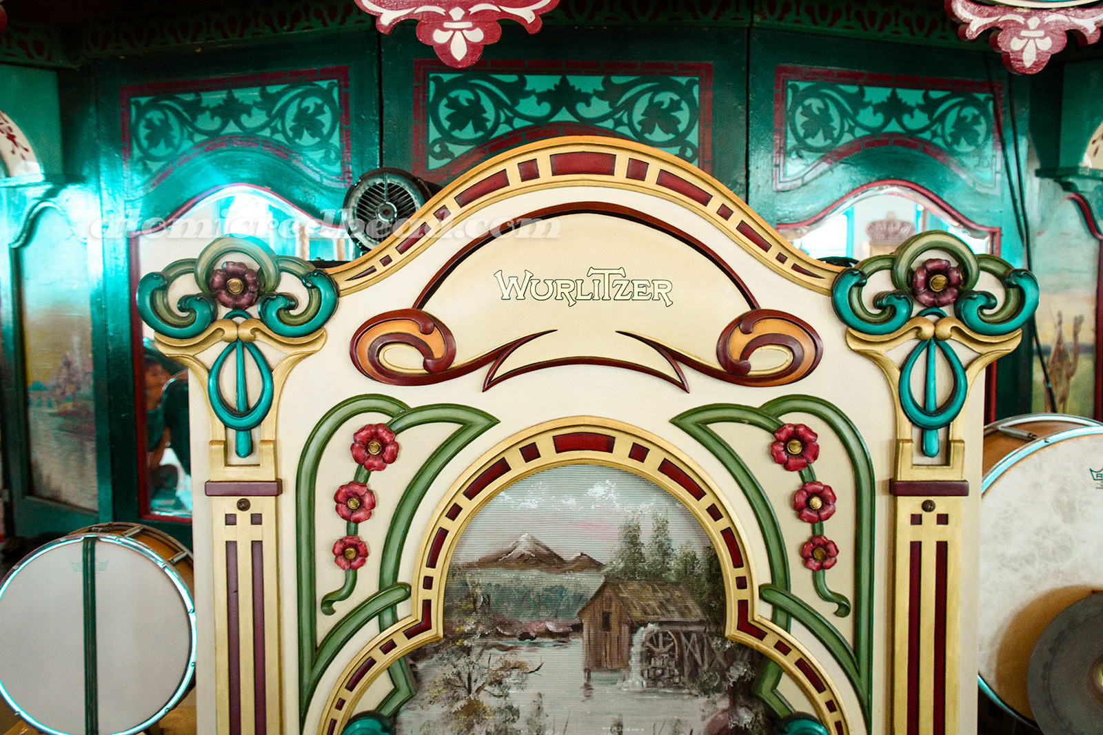 The Wurlitzer for the carousel, painted in many different colors, and a scene of a cabin with a water wheel on the speaker.