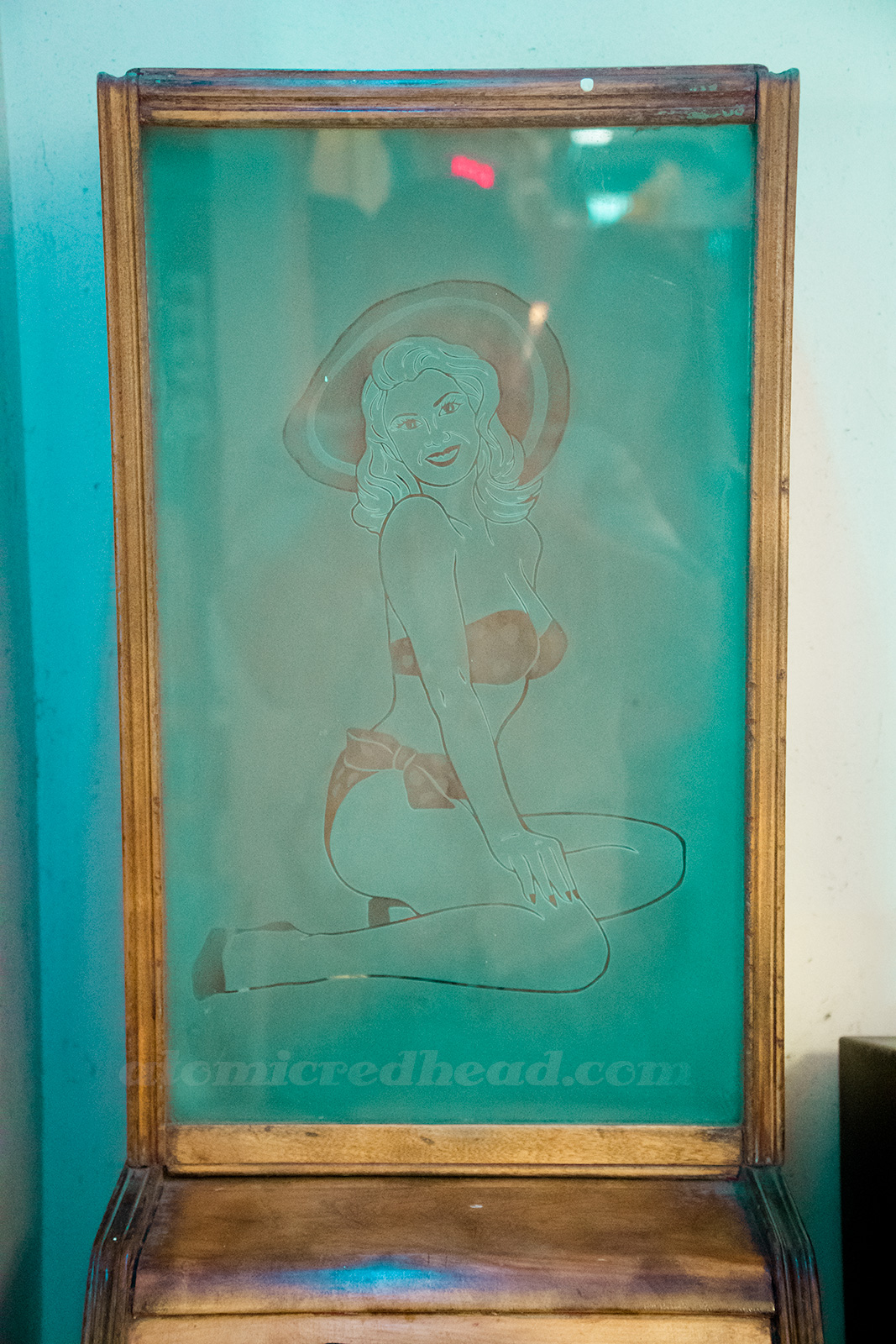 Inside Playland - a 1950s etched glass of a pin-up in a bikini and large sunhat to advertise what was likely a cheesecake show to watch.