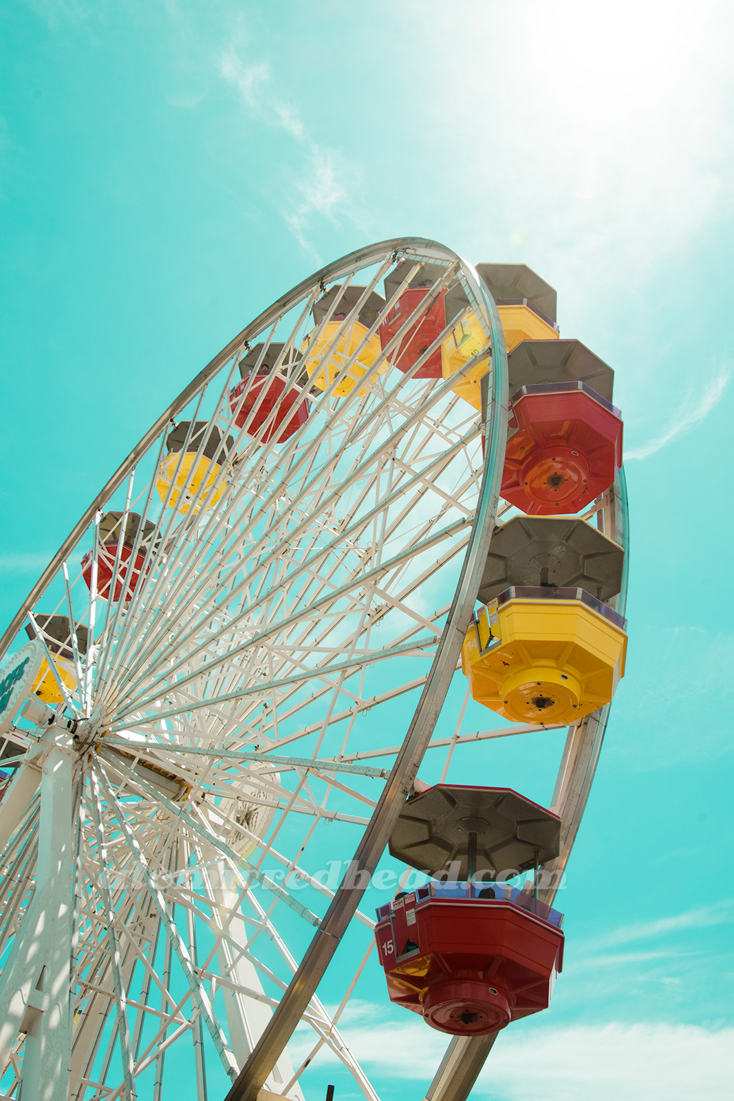 The ferris wheel at Pacific Park, with baskets of red and yellow.
