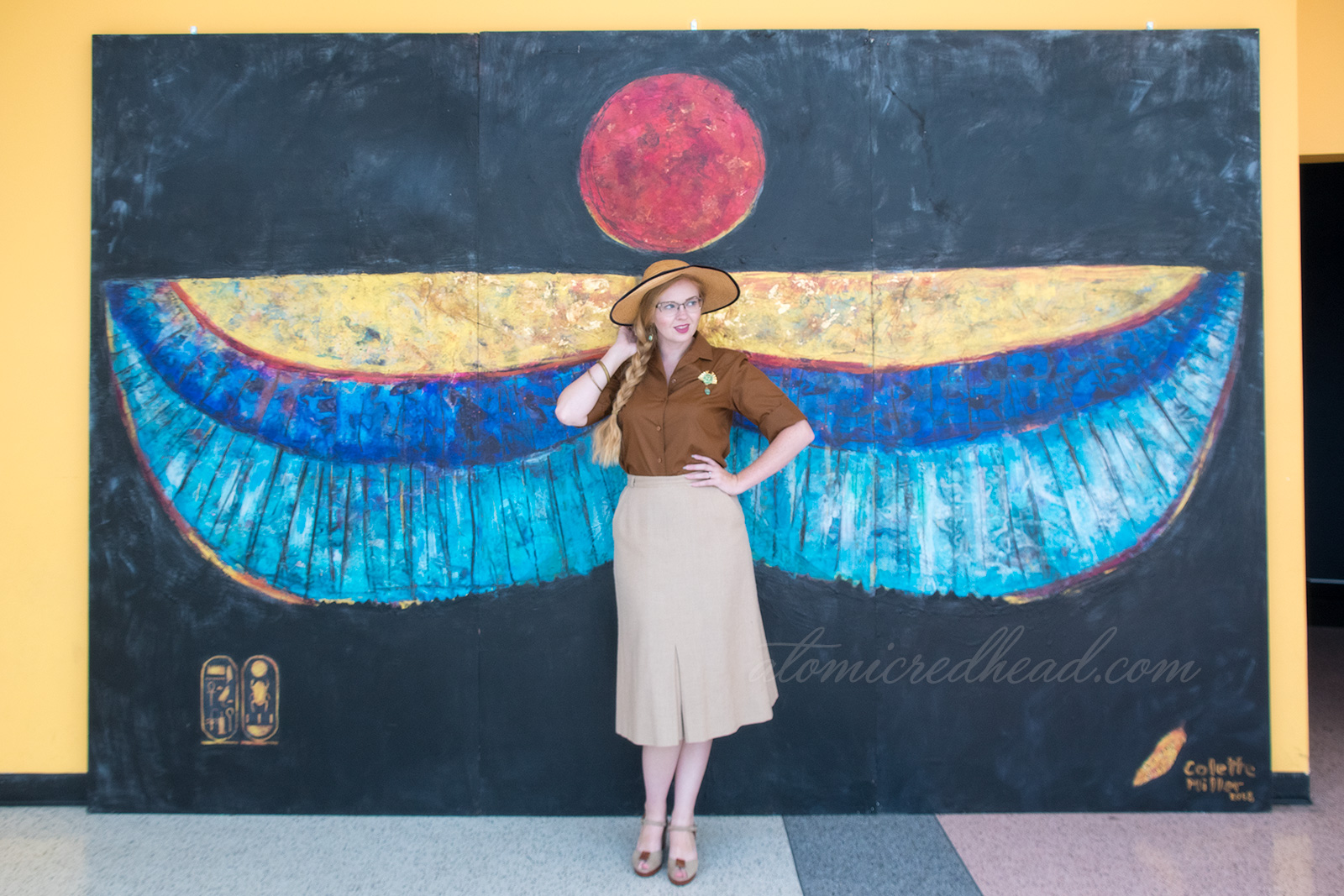 A mural featuring Egyptian style wings with the sun above.