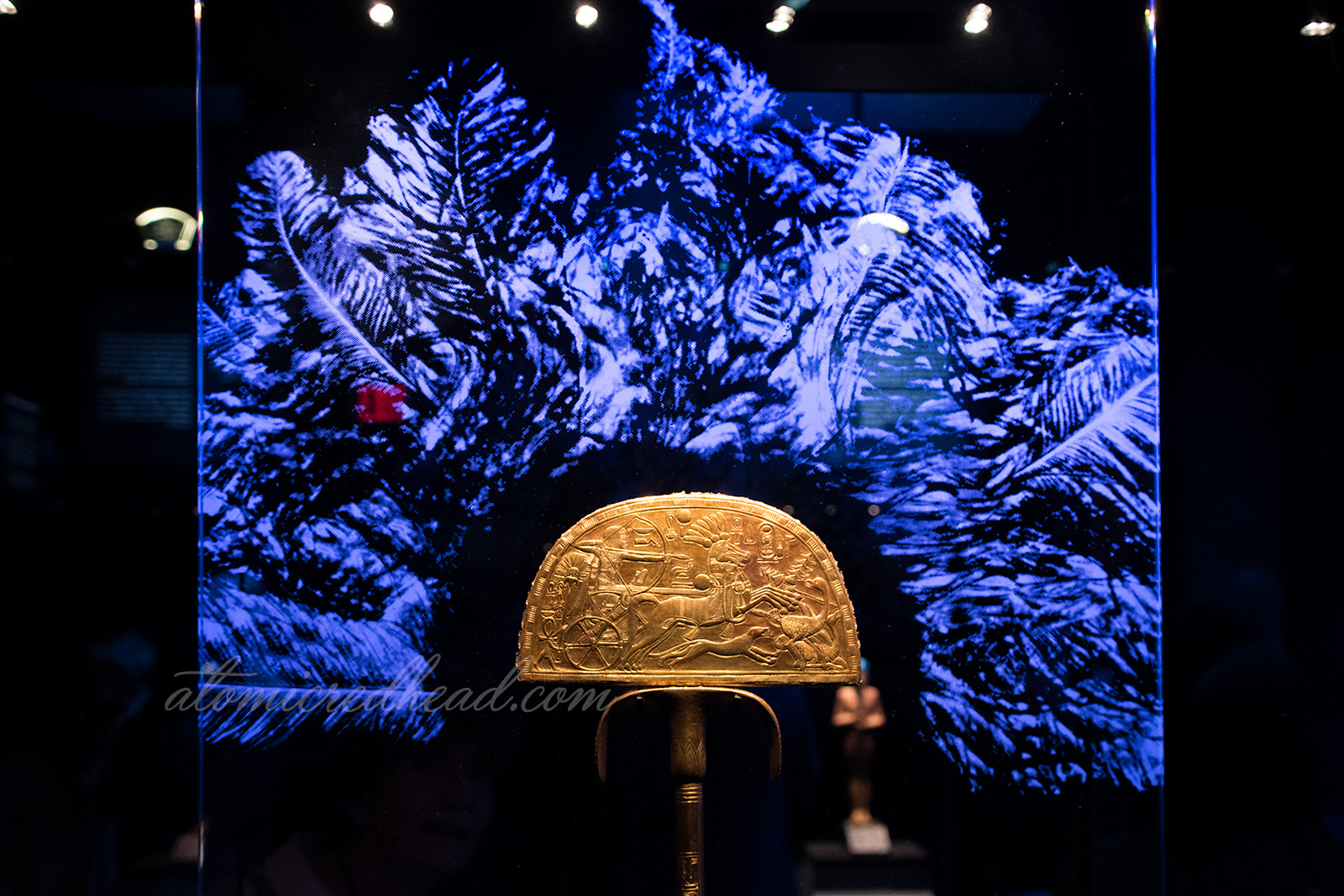 The center of a large fan, the gold image feature Tut hunting ostriches, which would have been the feathers to make up the fan.