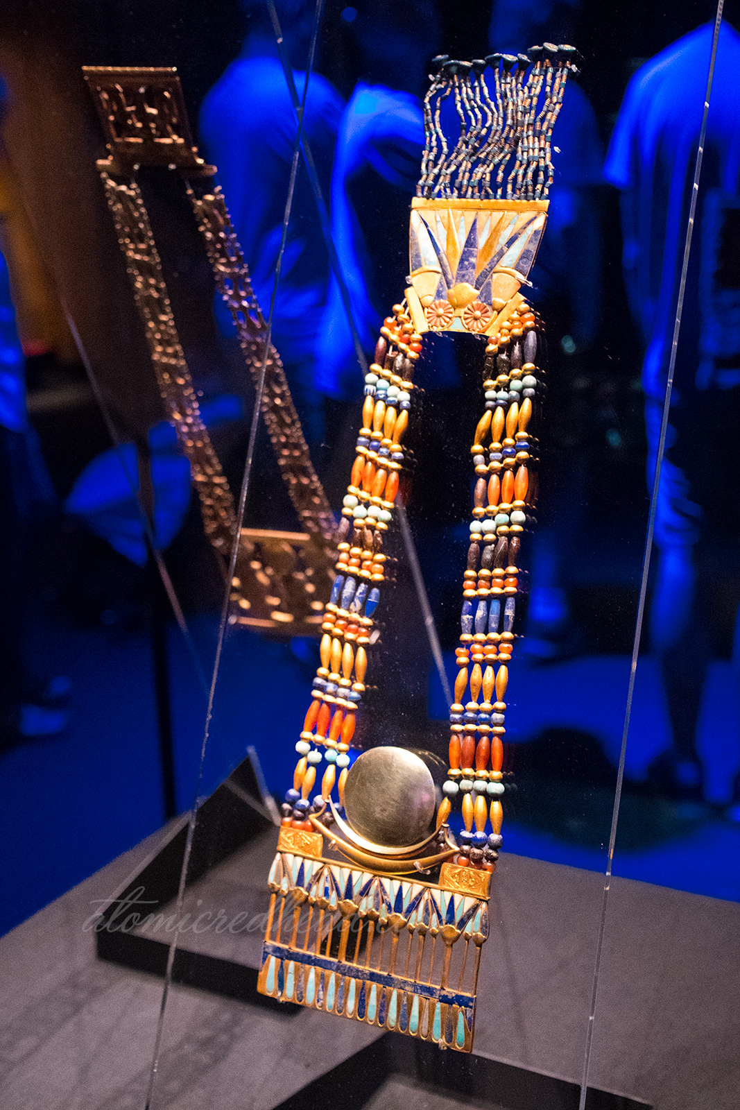 A necklace of beads and gold featuring the sun and lotus flowers