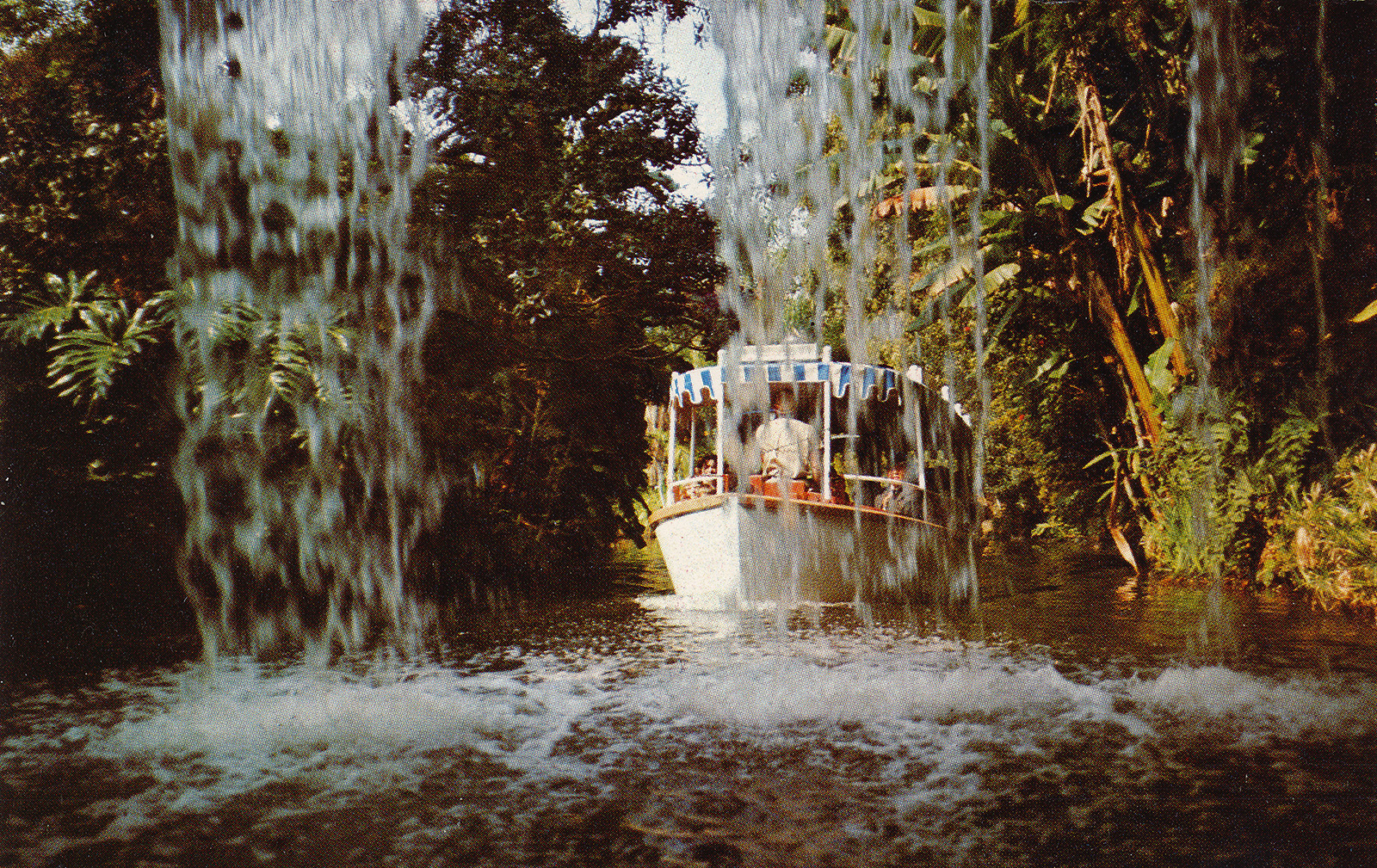 A Jungle Cruise boat glides by Schweitzer Falls.