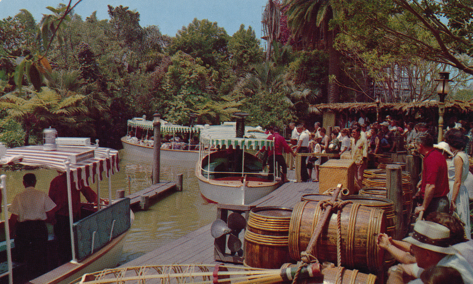 Guests board white boats with awnings of green and white stripes. 