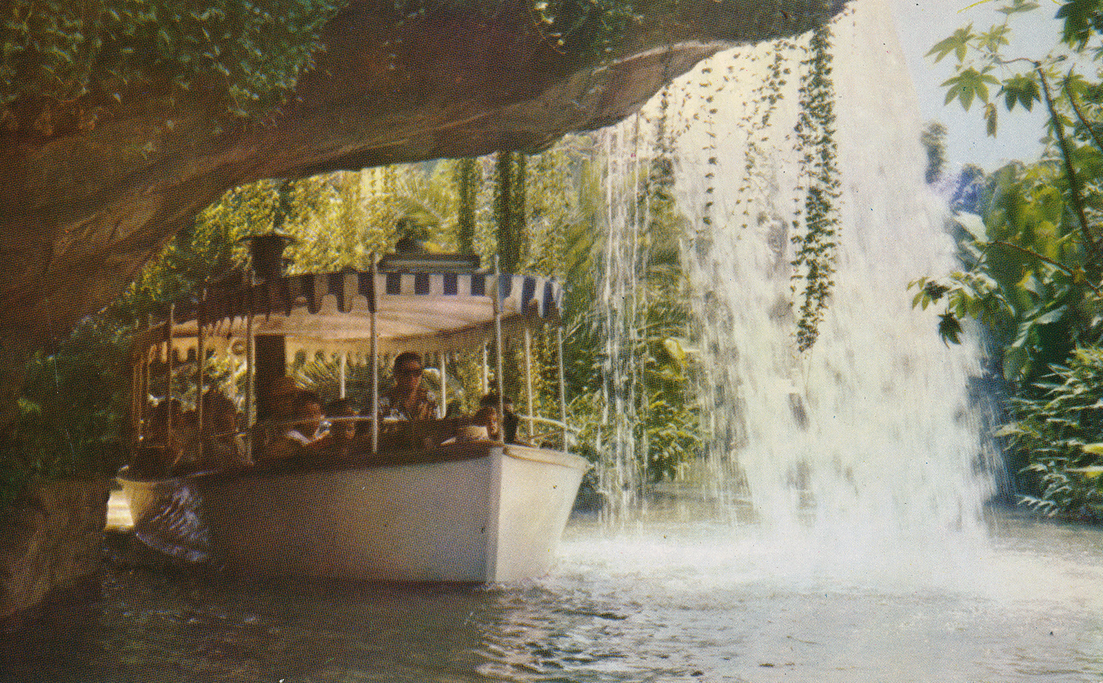 A Jungle Cruise boat sails under Schweitzer Falls.