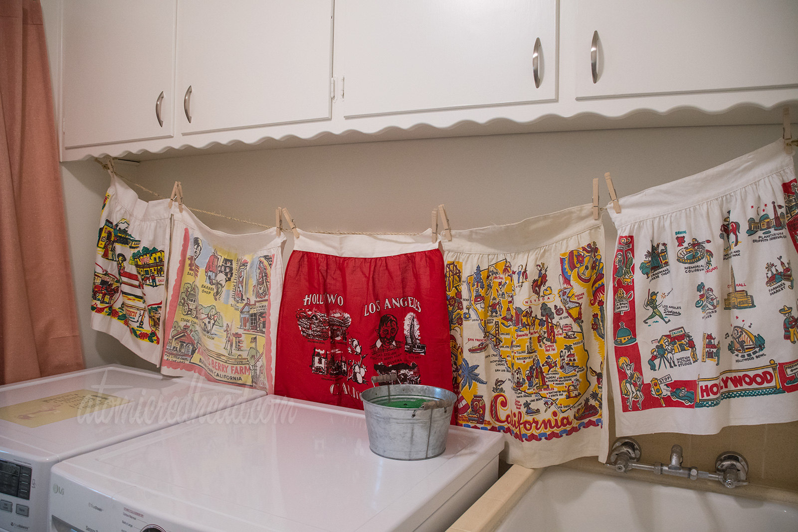 A look at the vintage linens above the washer and dryer. Two Knott's Berry Farm ones, a red one featuring landmarks of Hollywood and Los Angels, another featuring a map of California, and another with icons of Hollywood.