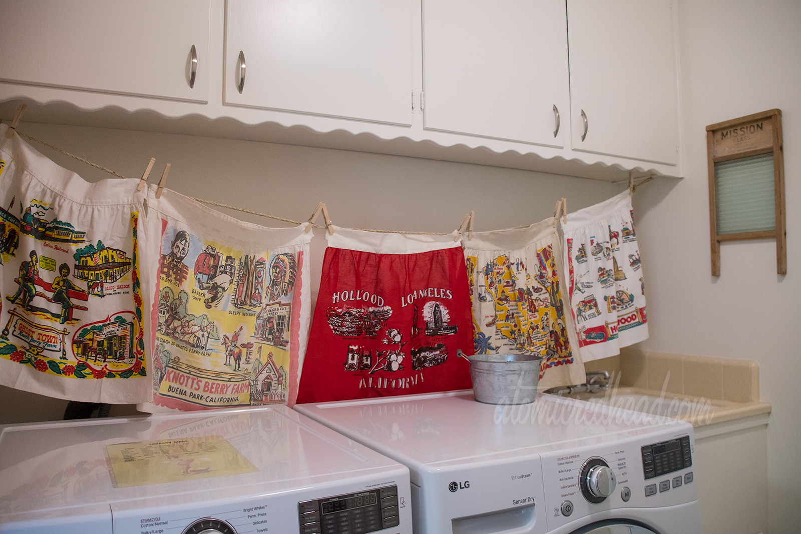 A look at the vintage linens above the washer and dryer. Two Knott's Berry Farm ones, a red one featuring landmarks of Hollywood and Los Angels, another featuring a map of California, and another with icons of Hollywood.