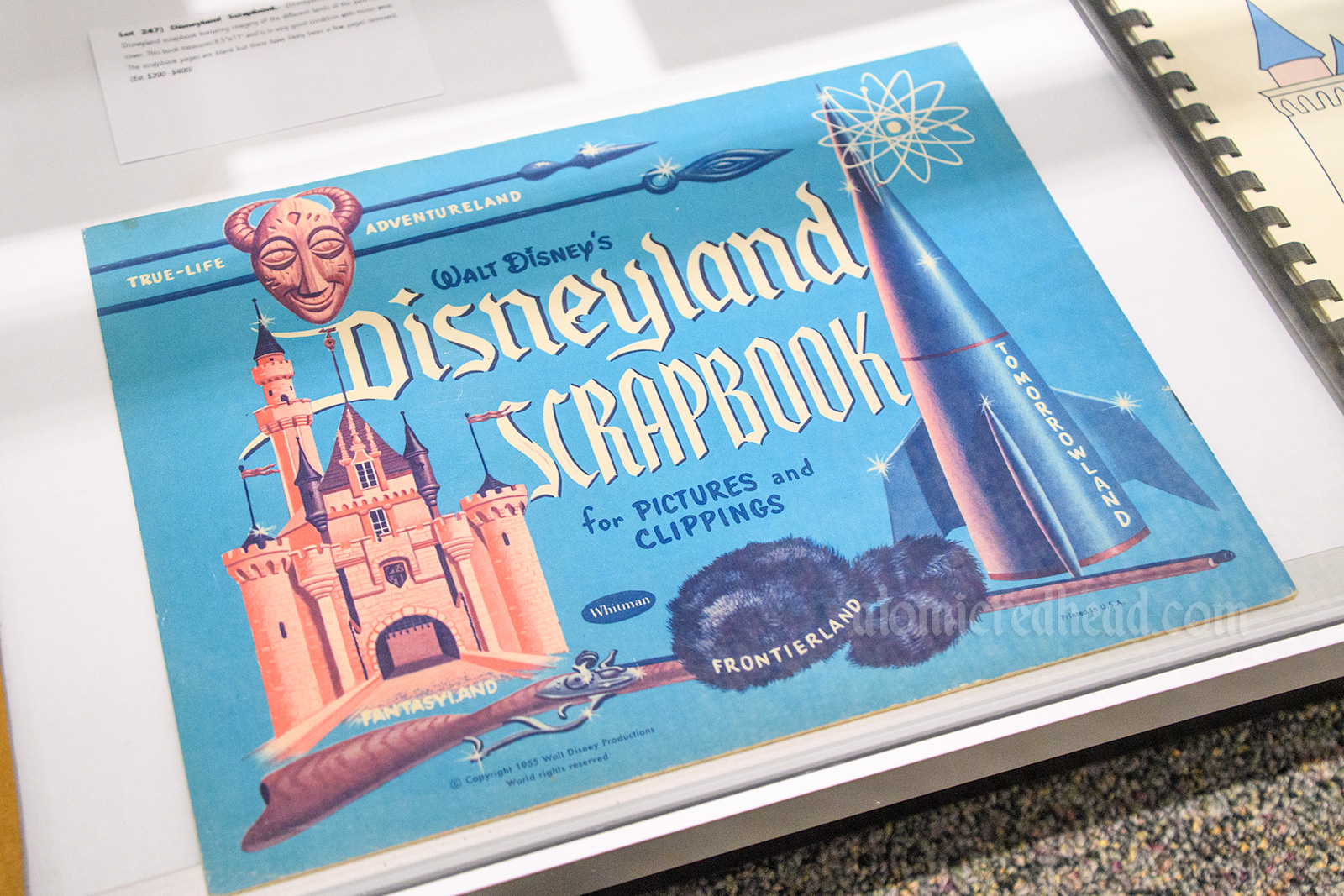 Vintage Disneyland scrapbook with illustrated images of the castle, rocket, Davy Crockett cap, and tiki mask.