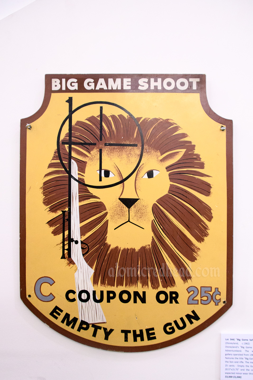 Sign from the "Big Game Shoot" shooting gallery that was in Adventureland, and features a lion and gun. Also reads "C Coupon or 25 cents Empty the Gun"