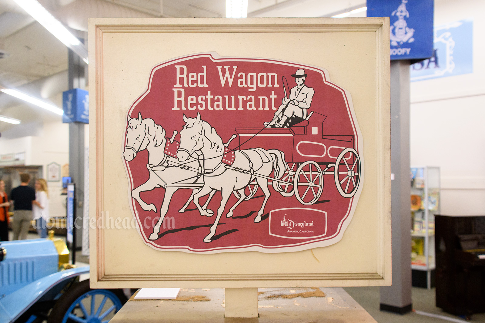 Signage for the Red Wagon Restaurant, featuring an illustration of a gentleman in a hose drawn red wagon.