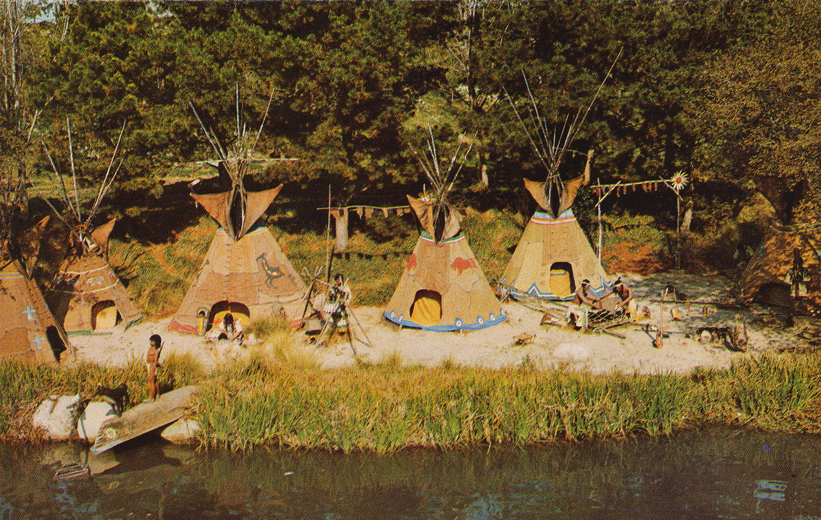 A trio of tipis and Native Americans rest along the banks of the Rivers of America.