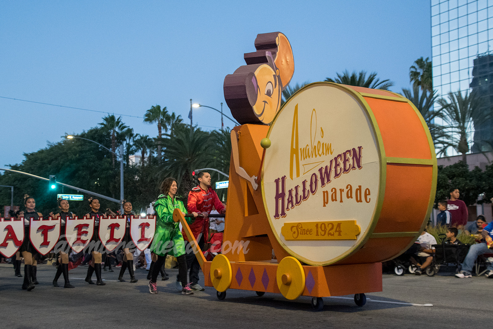 Andy of Anaheim, the chipmunk-esque mascot of Anaheim bangs a drum reading "Anaheim Halloween Parade Since 1924" 