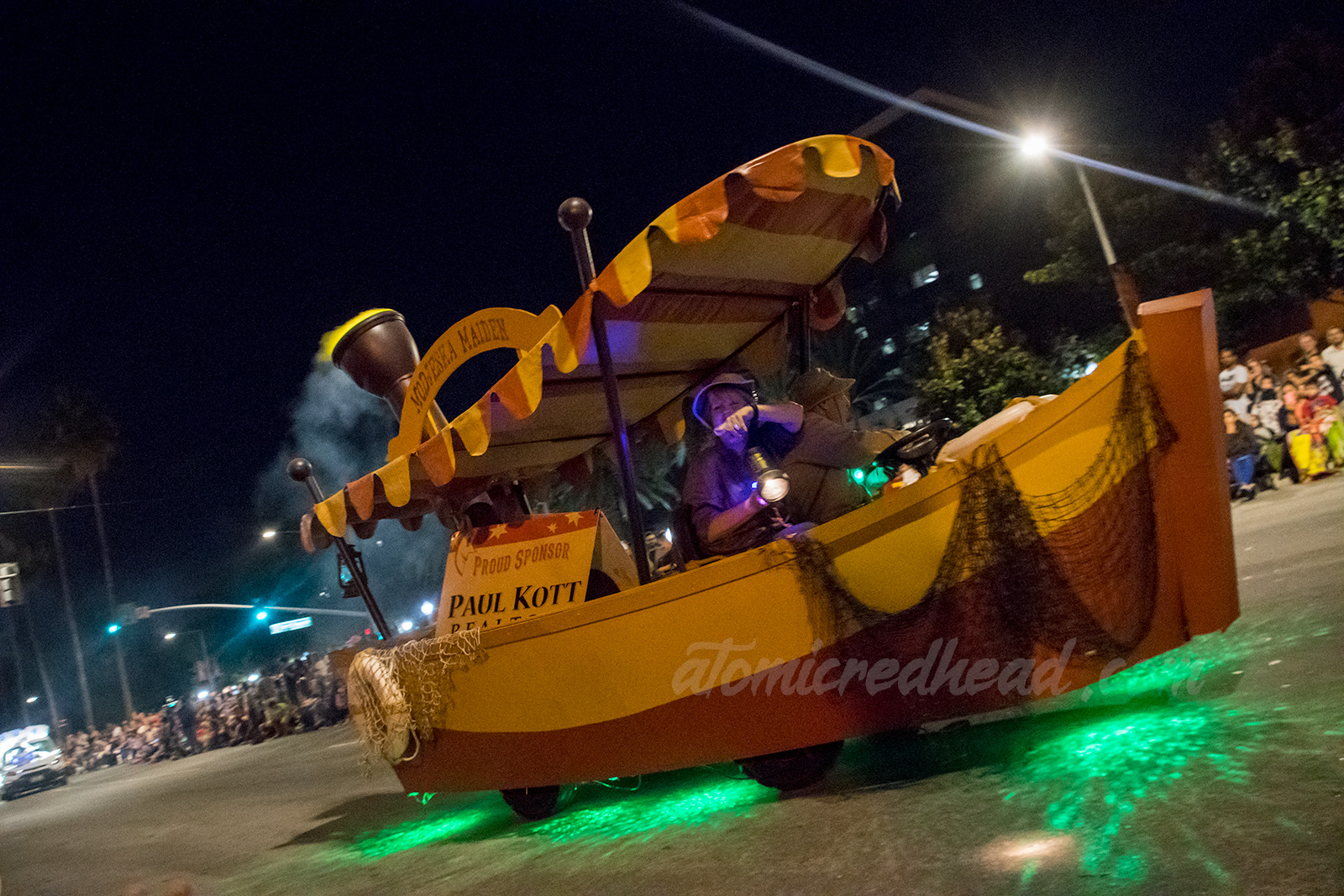 A float of a cartoon Jungle Cruise style boat, with orange and yellow stripe canopy.