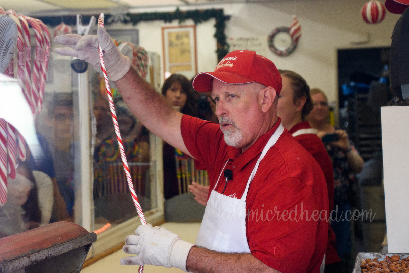 After twisting the sugar to make the spiral design, Jerry holds up a rope of the spiraling candy.