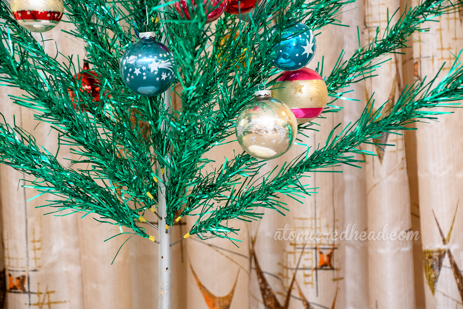 A close up of the trunk of the green aluminum tree showcasing empty branch holes.