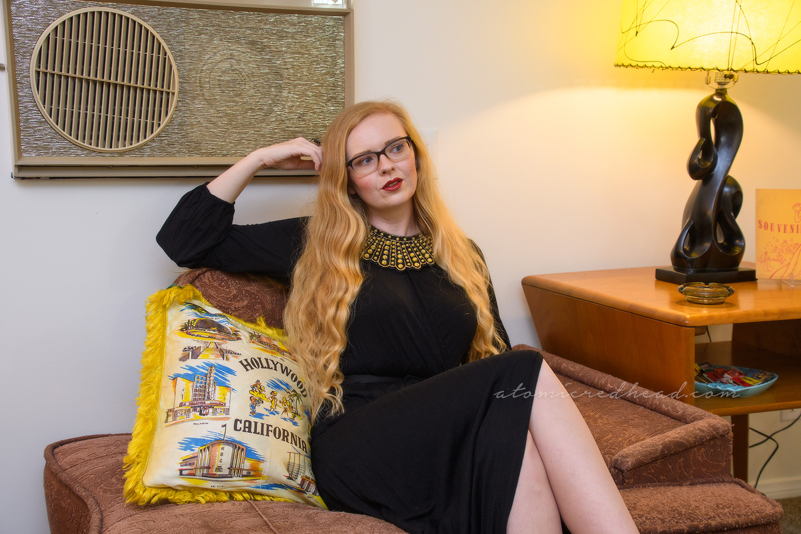Seated, wearing a long sleeve full length dress, and gold rhinestone dissent collar.