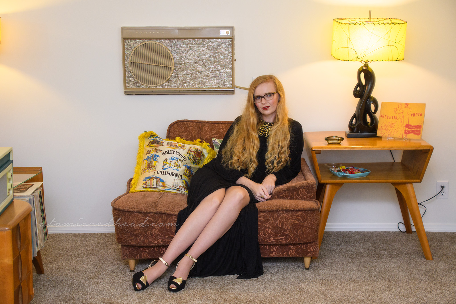Seated, wearing a long sleeve full length dress, and gold rhinestone dissent collar.