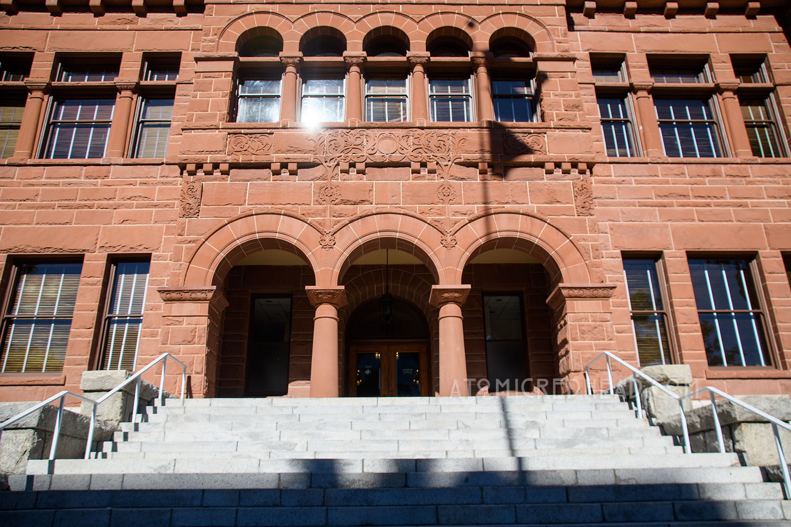 The Old Orange County Courthouse, a large, three-story building made of red sandstone. It features three small arches in the center mark the entrance. Three gables top the roofline.