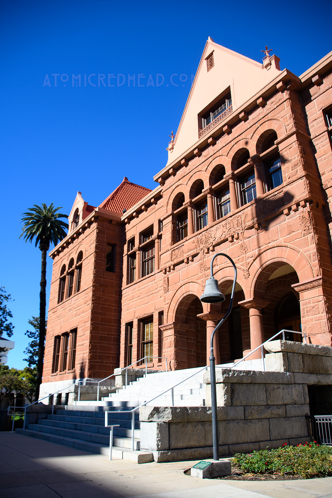 The Old Orange County Courthouse, a large, three-story building made of red sandstone. It features three small arches in the center mark the entrance. Three gables top the roofline.