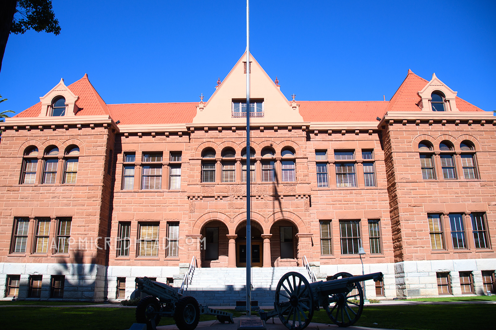The Old Orange County Courthouse, a large, three-story building made of red sandstone. It features three small arches in the center mark the entrance. Three gables top the roofline.