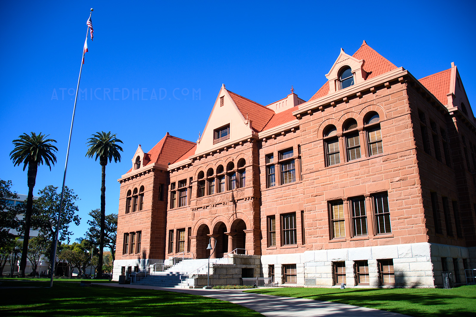 The Old Orange County Courthouse, a large, three-story building made of red sandstone. It features three small arches in the center mark the entrance. Three gables top the roofline.
