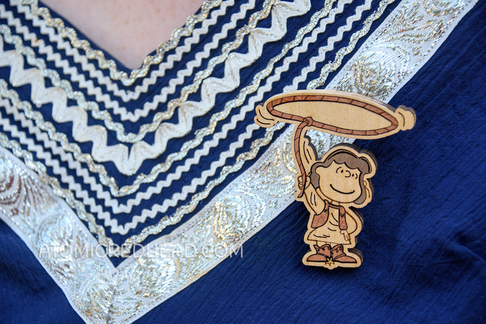 Close-up of my brooch, which is laser cut wood of cowgirl Lucy with a lasso above her head.