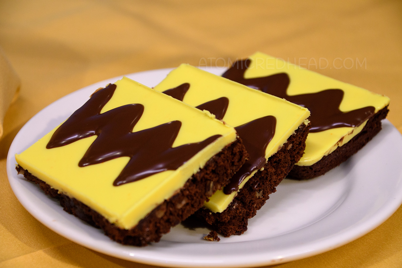 Brownies frosted in yellow frosting with a dark brown zig-zag emulate Charle Brown's t-shirt.