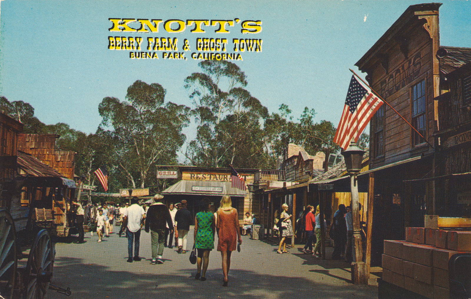 Guests walk down an old western street. Yellow text reads "Knott's Berry Farm & Ghost Town Buena Park, California"