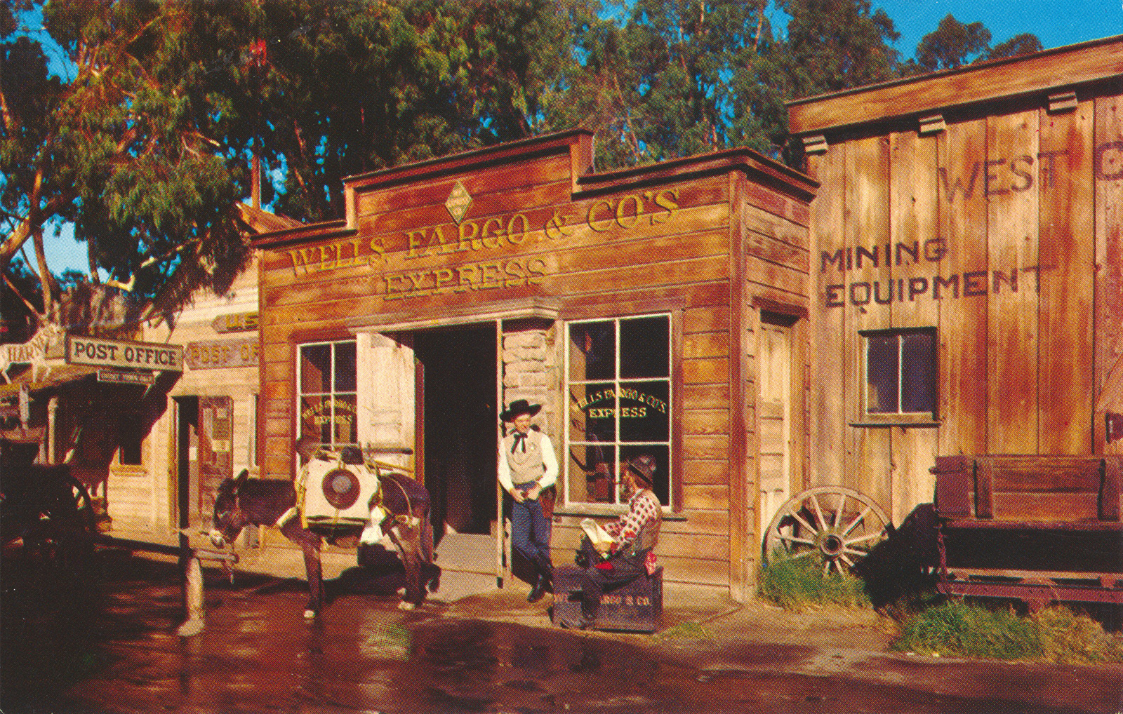 Cowboys stand in front of a wooden building reading "Wells Fargo & Co's Express"