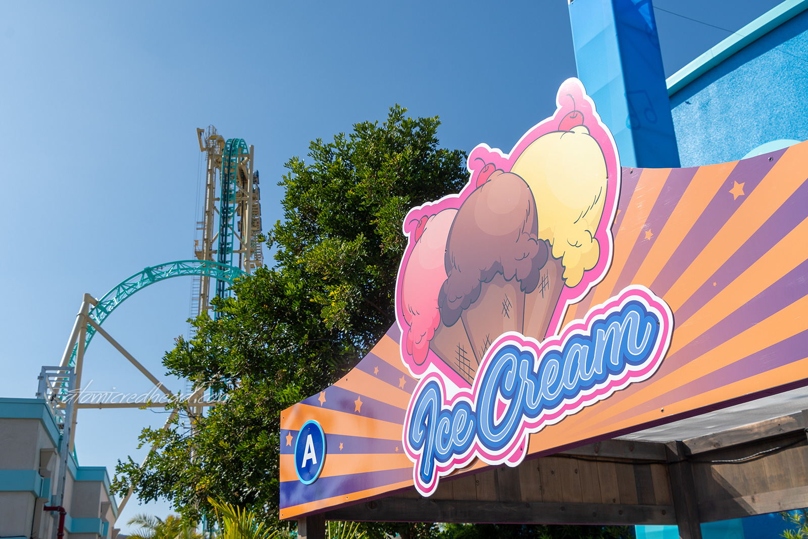 One of the food stands, with a brightly colored sign featuring images of ice cream cones and blue text reading "Ic Cream"