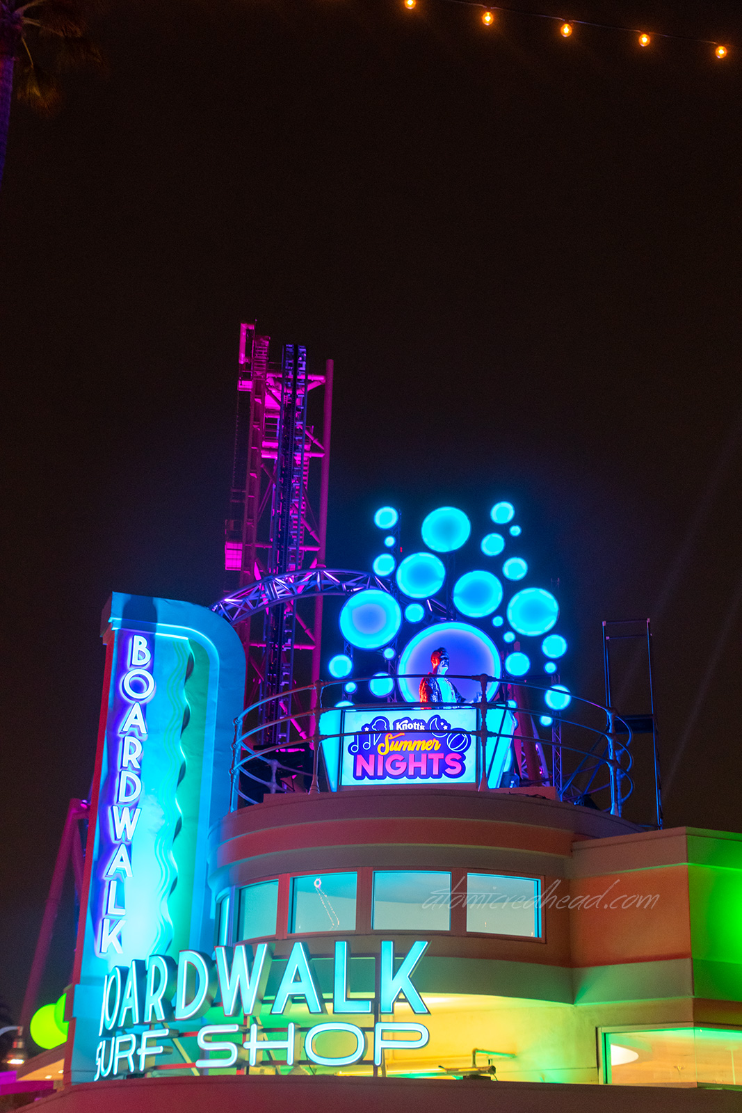 A live DJ stands atop the Boardwalk Surf Shop.