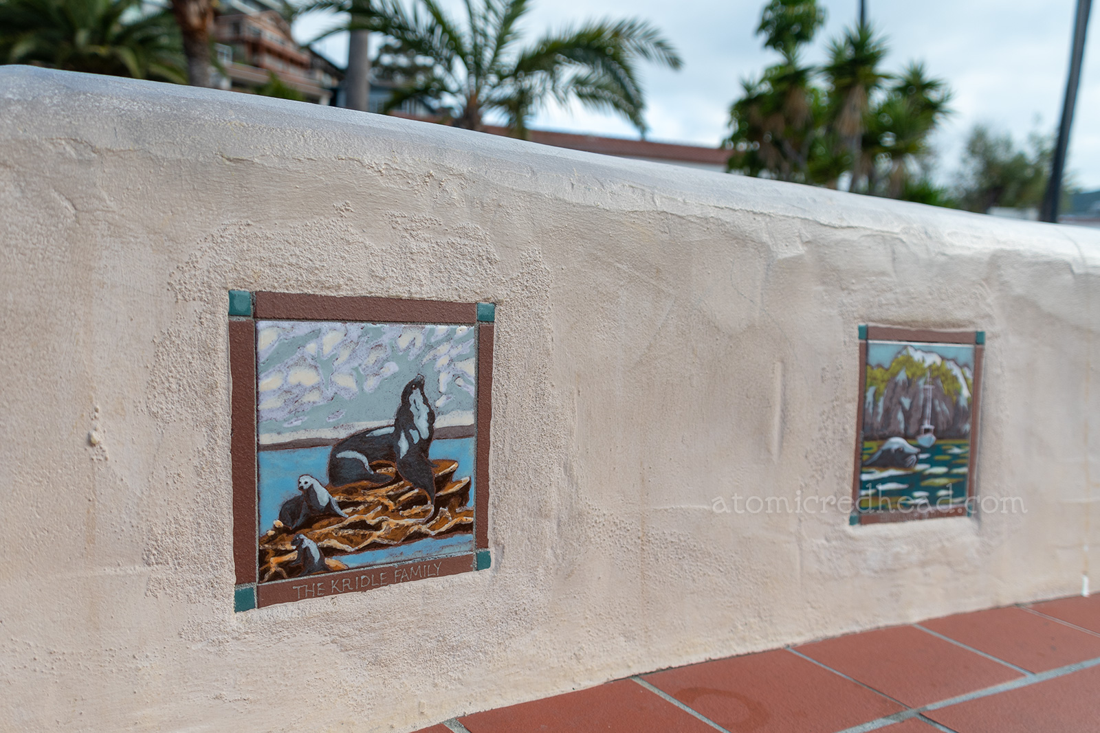 Colorful tiles featuring images of sea lions are set into an adobe walled bench.