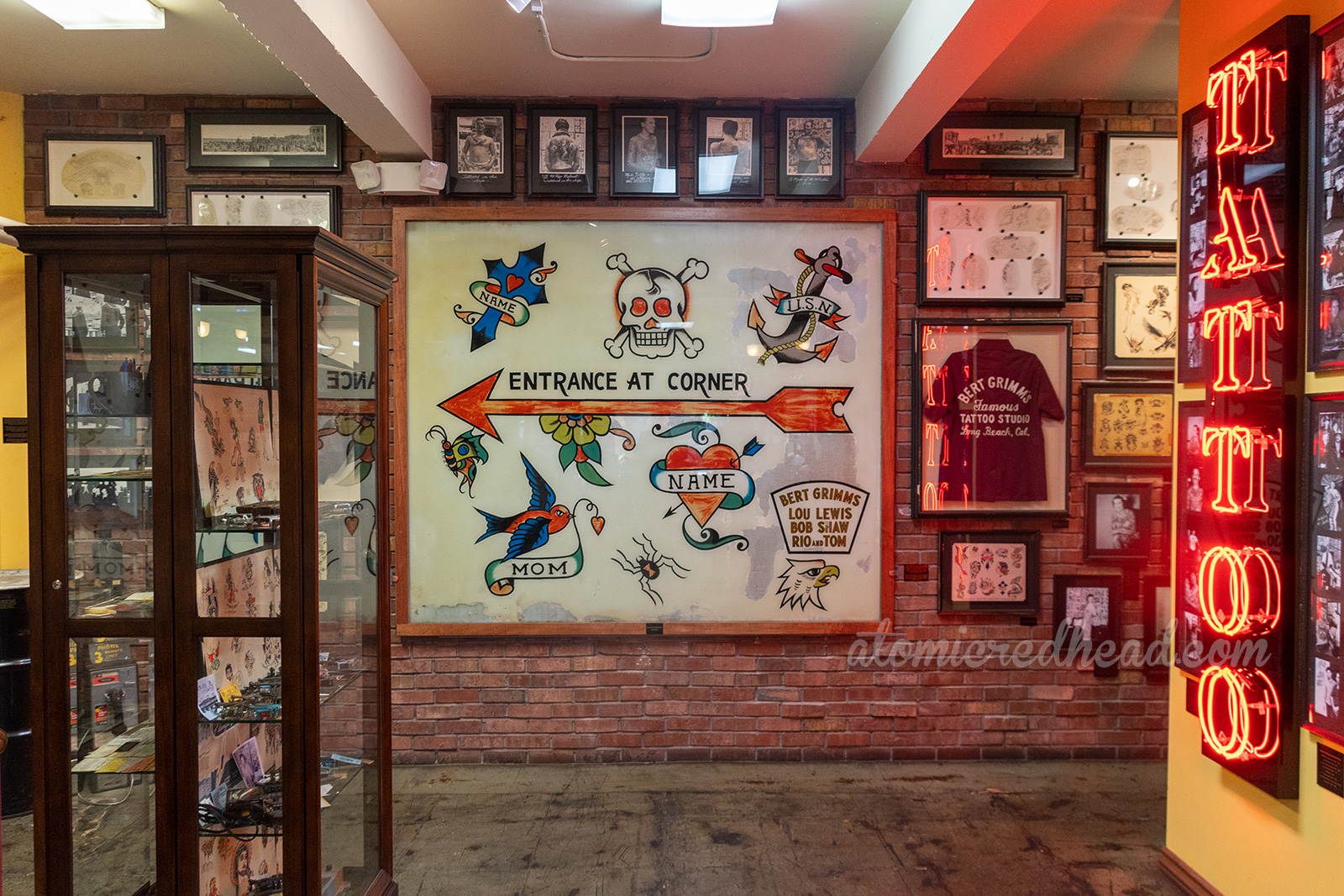 Overall view of the museum portion of Outer Limits, including a massive hand-painted window with iconic tattoo images of skulls, crosses, hearts, anchor, text reads "Entrance on Corner"
