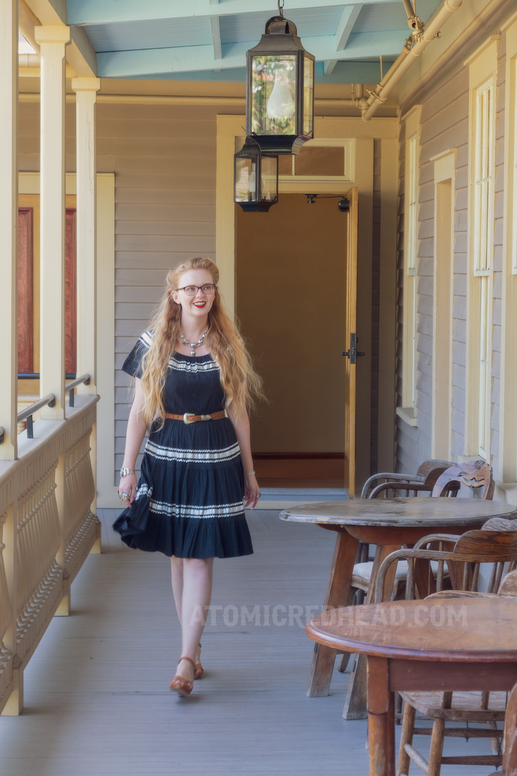 Myself walking on the upper balcony, wearing a black dress with silver trim.