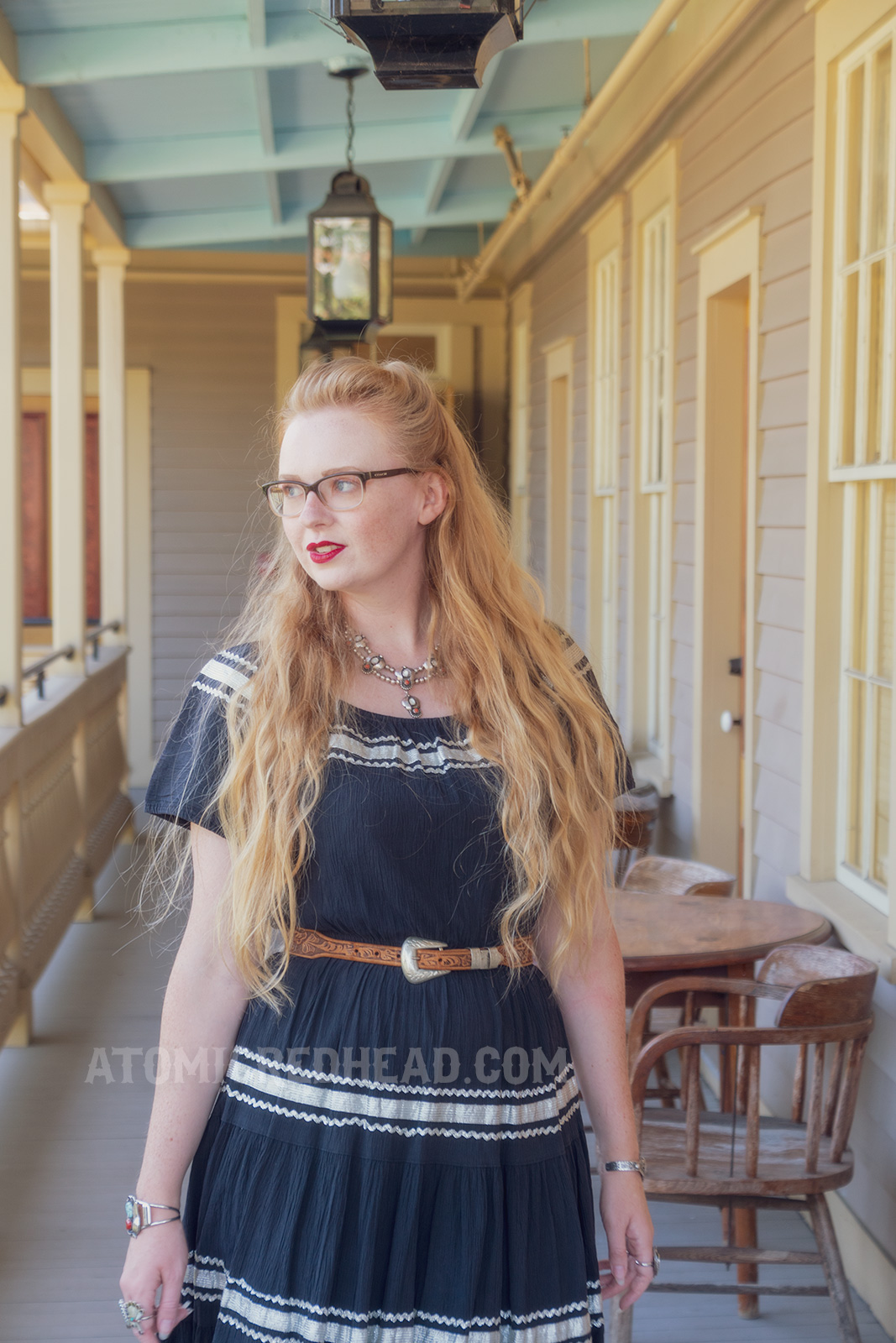 Myself walking on the upper balcony, wearing a black dress with silver trim.