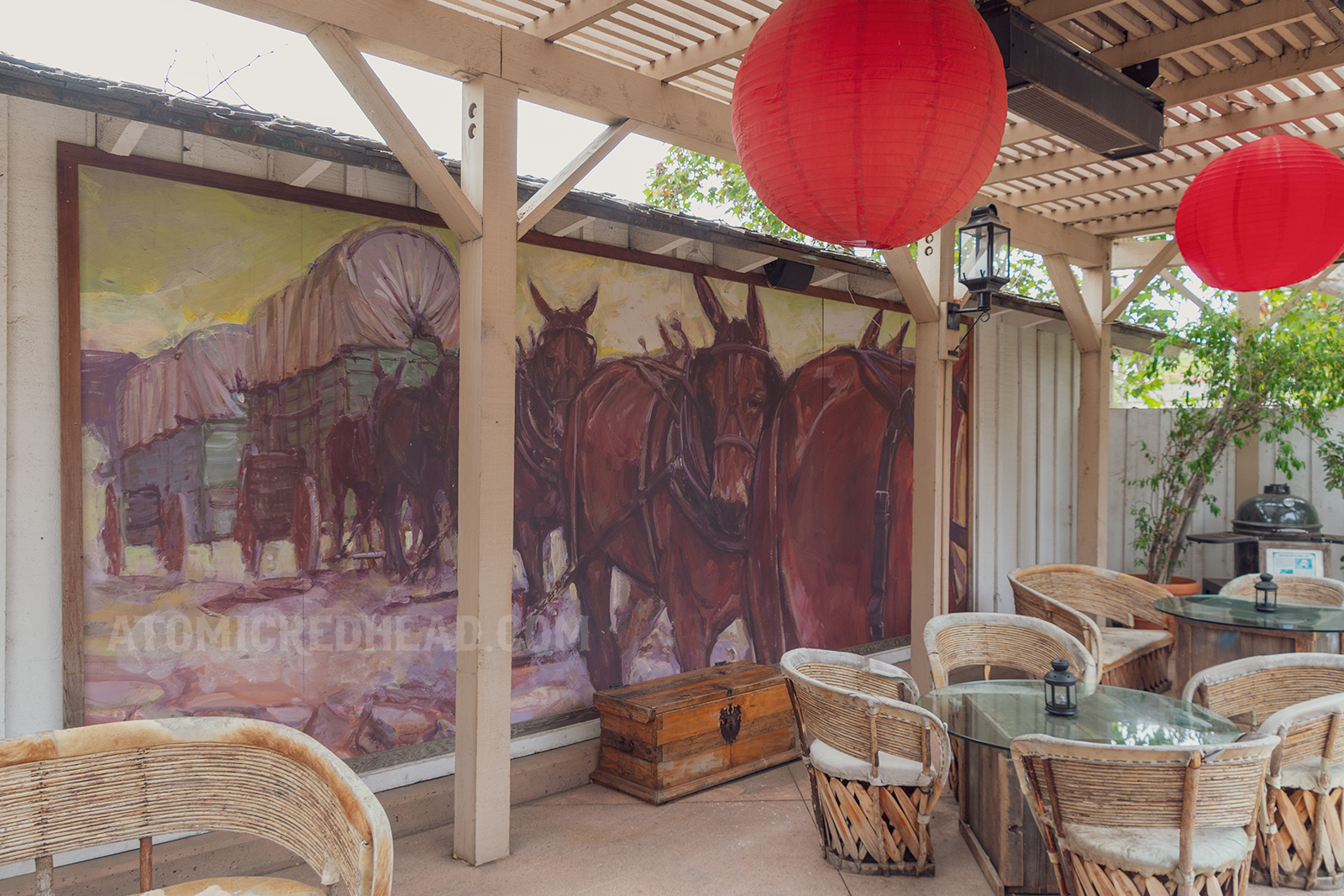 A mural of a covered wagon being pulled by horses on a wall of the outdoor courtyard.