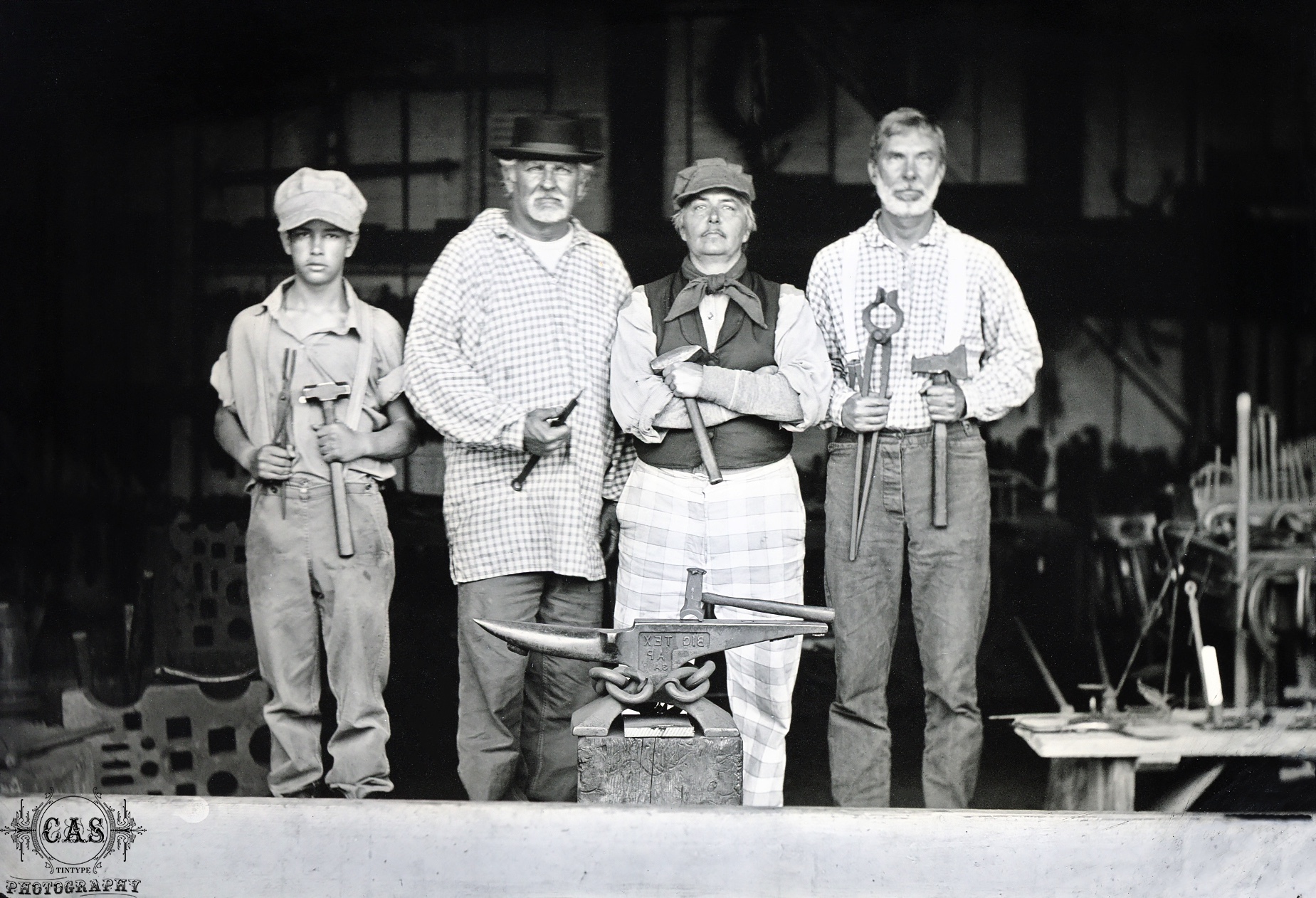 A black and white image taken by Catherine, of four men in period attire in the blacksmith shop.