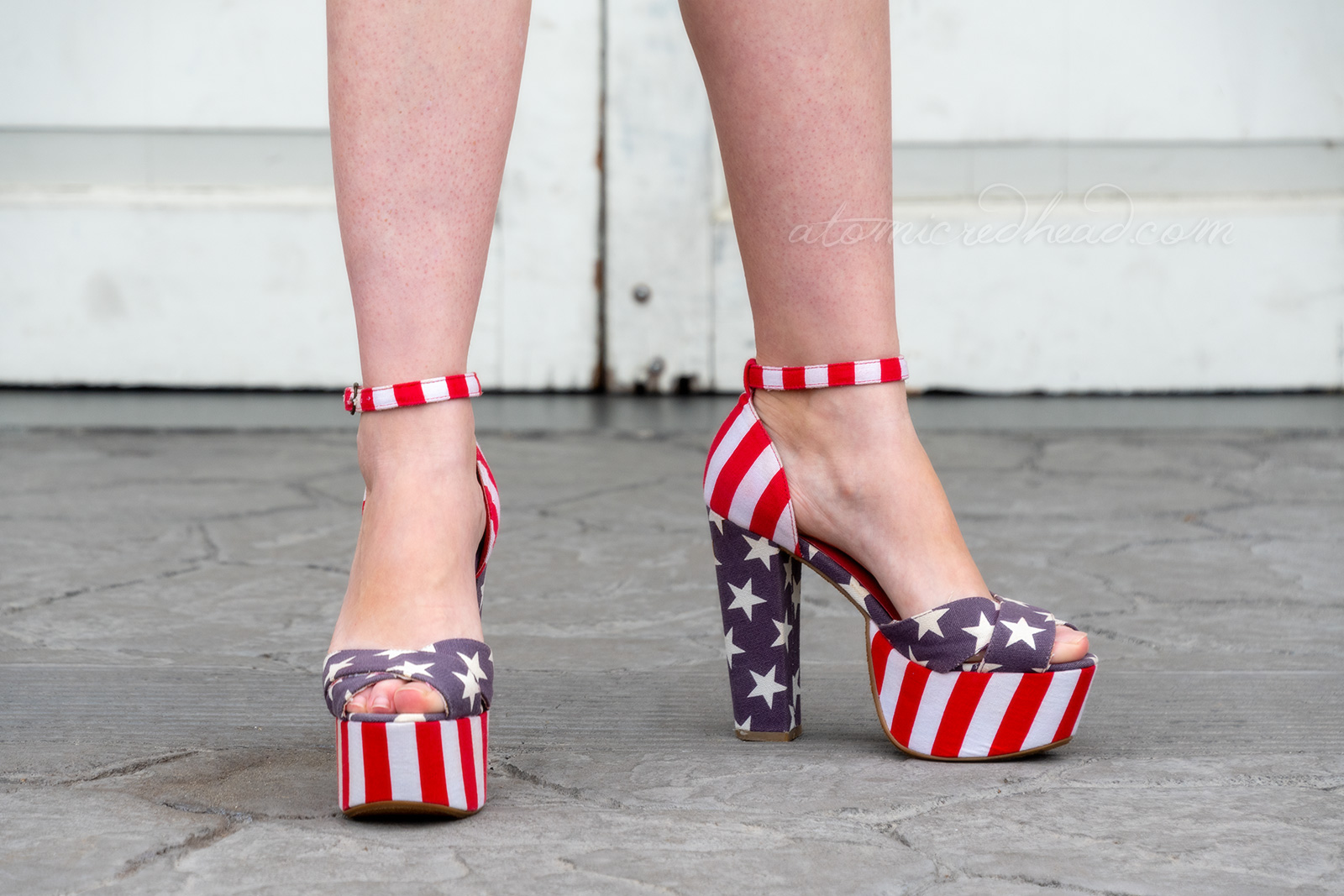 Close up of my shoes. The front platform features red and white stripes, the back heel is blue with white stars. The top part over the toes is blue with white stripes, and the heel and ankle strap are red and white stripes.