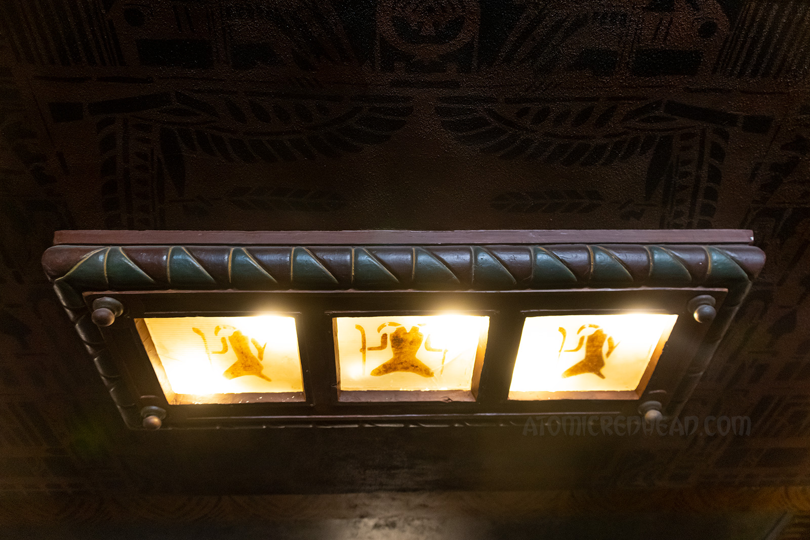 A three panel light figure features hieroglyphs. 